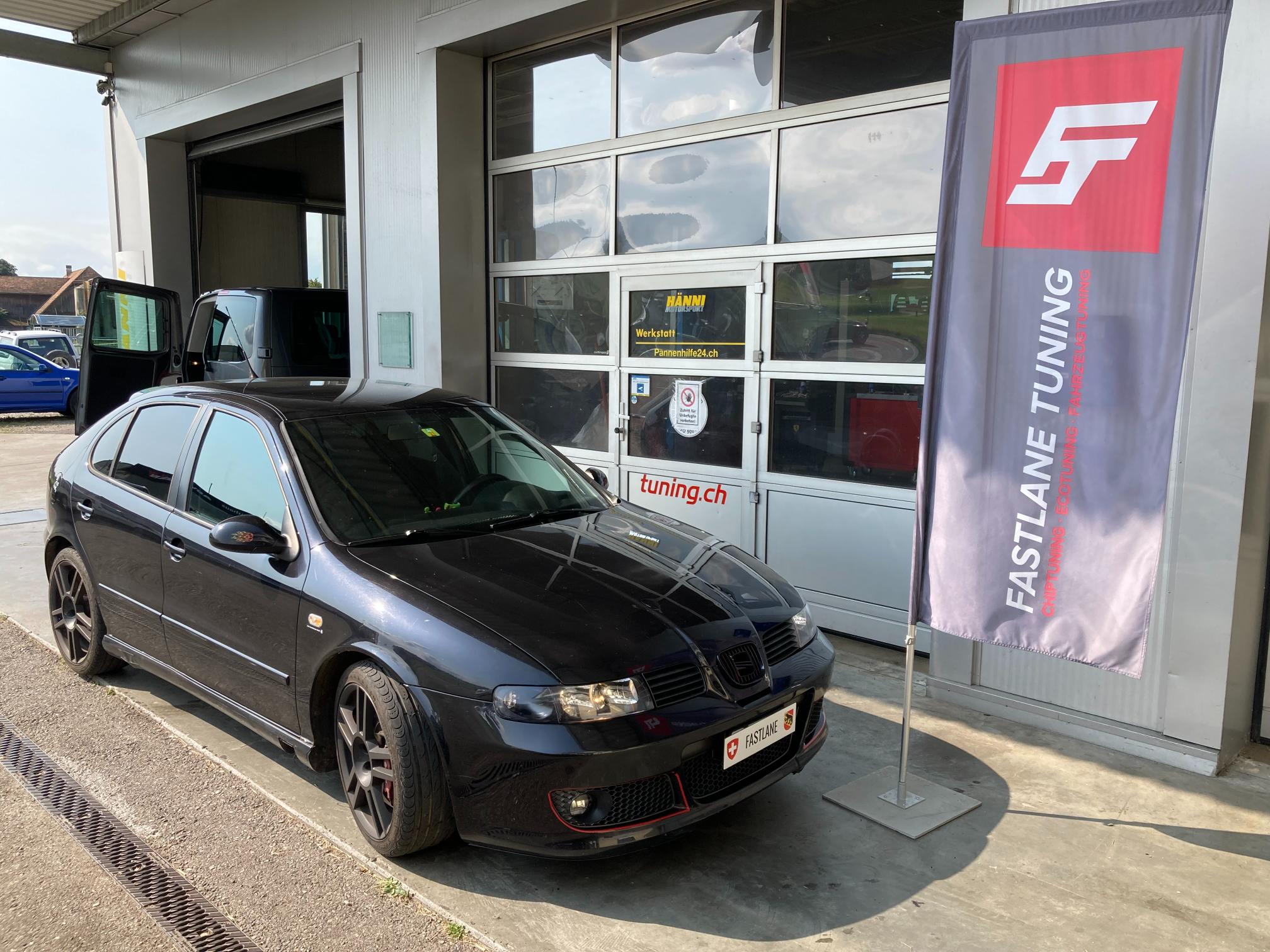 Ein schwarzer SEAT Ibiza Cupra R steht vor der Garage neben der Fastlane Tuning Schweiz Flagge