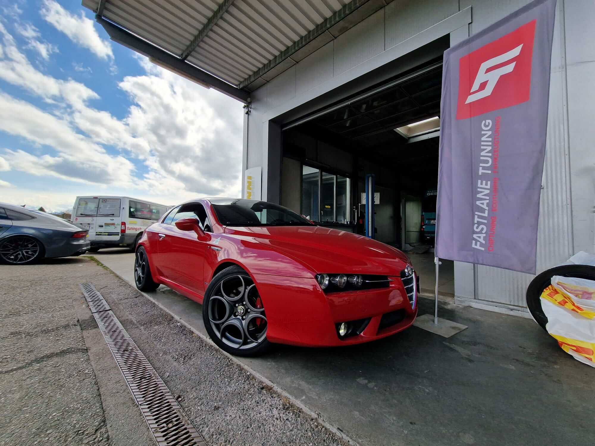 Ein roter Alfa Romeo Brera 1.8 TBi steht vor der Garage von Fastlane Tuning Schweiz