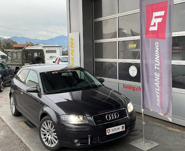 Ein schwarzer Audi A3 3.2 Liter V6 quattro steht neben der Fastlane Tuning Schweiz Flagge