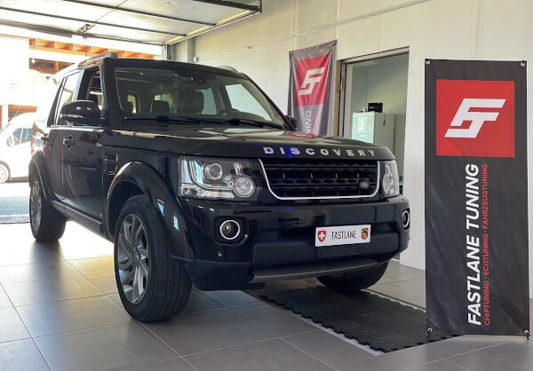 Ein schwarzer Land Rover Discovery 4 SDV6 steht neben dem Banner der Fastlane Tuning Schweiz GmbH