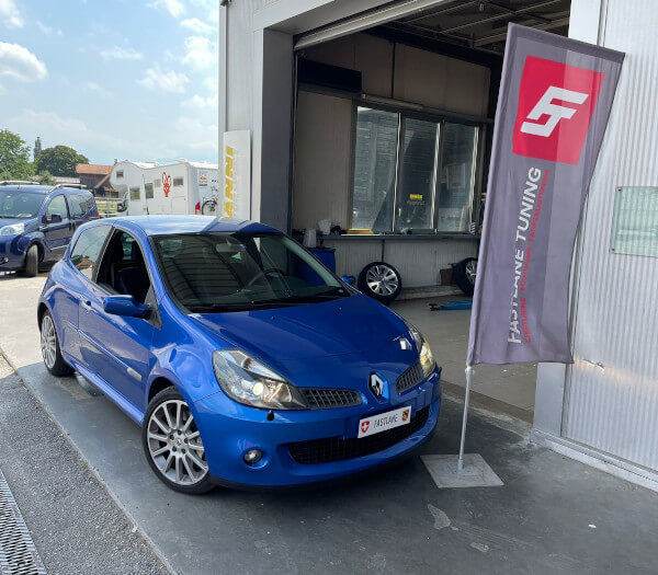 Ein blauer Renault Clio 3 Sport steht neben der Fastlane Tuning Schweiz Flagge.