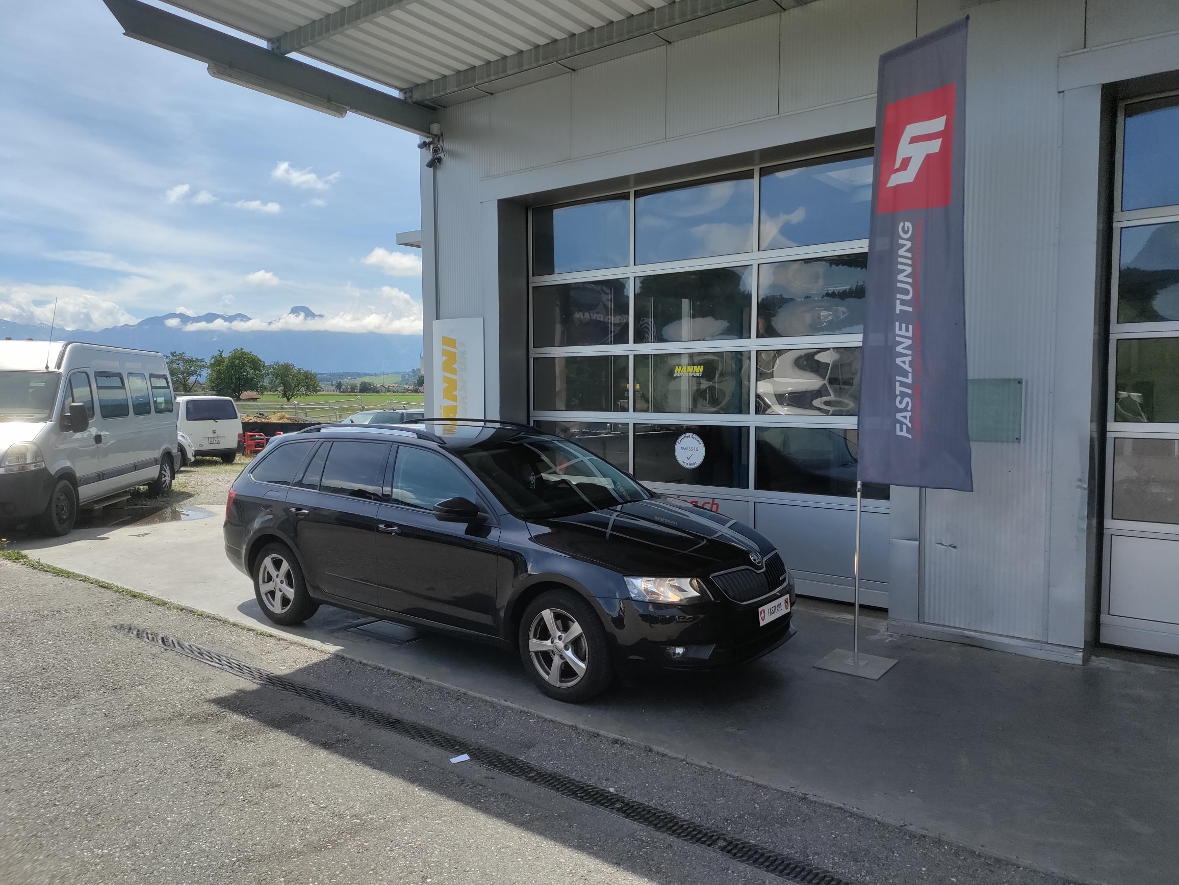 Ein schwarzer Skoda Octavia III 1.6 TDI greeline steht vor der Garage neben der Fastlane Tuning Schweiz Flagge