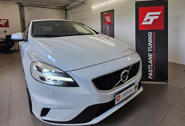 Neben dem Banner der Fastlane Tuning Schweiz GmbH steht ein weißer Volvo V40